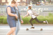 © guppys - girls are walking and a teenager is skateboarding in a summer city