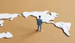 Among the world map puzzle the North American Map and standing miniature man.