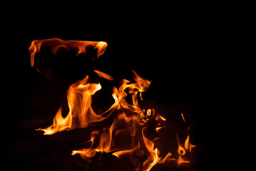 Flames in the fire of a red and yellow barbecue.