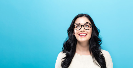 Wall Mural - Young woman looking upward on a solid background