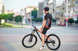 © anatoliy_gleb - Back view of athletic male bicyclist resting on bicycle after hard race. Sportsman taking break after morning outdoor activities riding bike. Concept of healthy lifestyle, exercising on fresh air