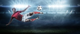 Fototapeta Sport - Soccer player in action on stadium background.