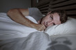 © TheVisualsYouNeed - restless worried young attractive man awake at night lying on bed sleepless having eyes opened depressed suffering insomnia sleeping disorder
