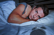 © TheVisualsYouNeed - restless worried young attractive man awake at night lying on bed sleepless having eyes opened depressed suffering insomnia sleeping disorder