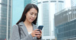 © leungchopan - Businesswoman check on smart phone in city
