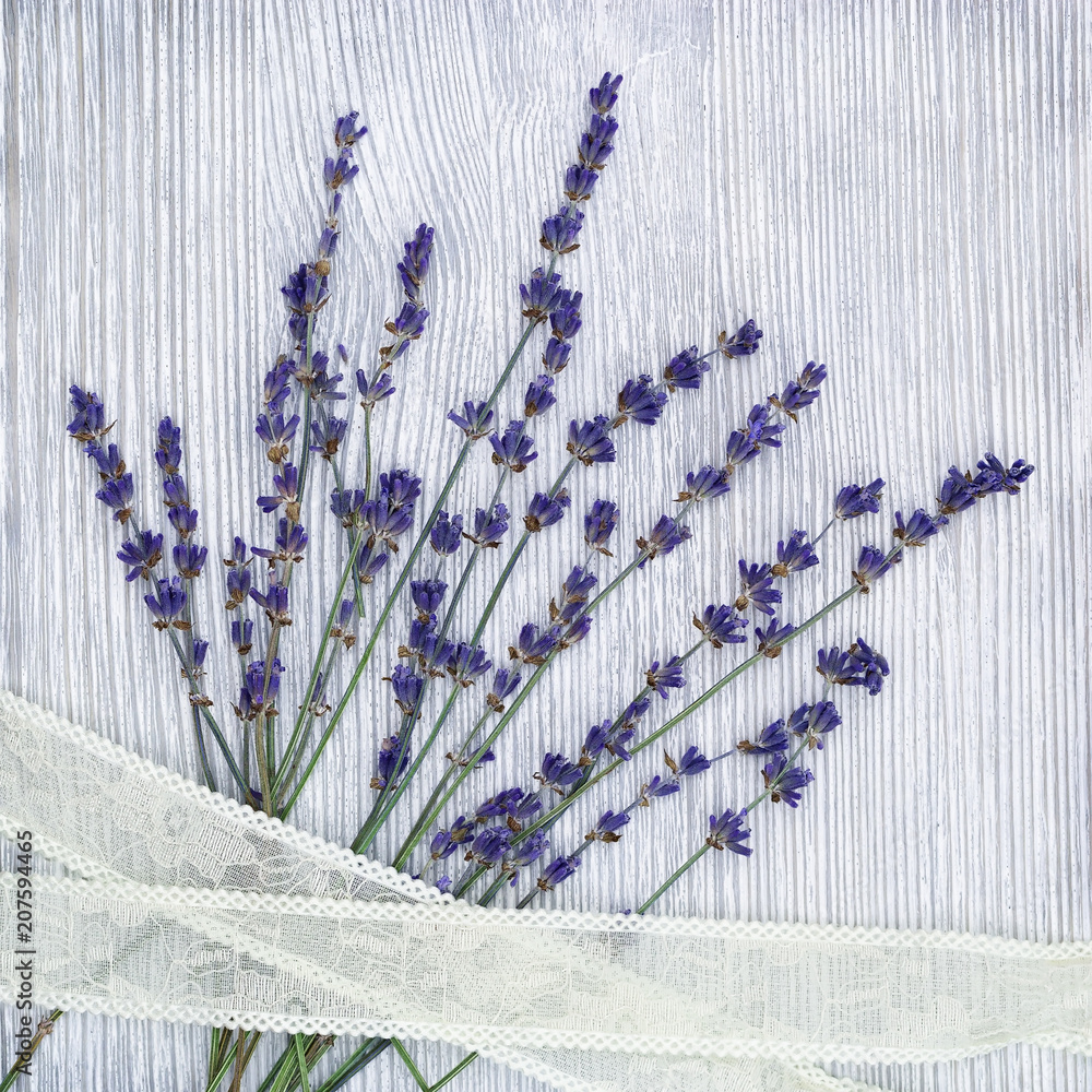 Obraz na płótnie Small flowers of lavender with lace braid on gray wood background with copy space. Top view. Provans style photography w salonie