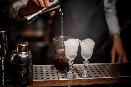 Fotografie, Obraz Bartender pouring alcoholic drink into the glass for making fresh summer cocktai