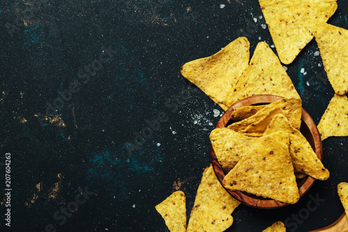 Fotografía Salted Mexican Corn Nachos iIn Wooden Bowl, Black Background, Top View