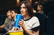 © Nomad_Soul - Woman with beverage and popcorn sitting in cinema