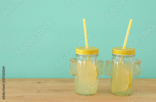 Fotografía Image of fresh lemonade drink in cute cactus shape glasses over wooden table