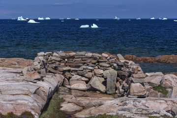 Wall Mural - hunter's blind made with rocks, Fogo Island, Newfoundland; icebergs