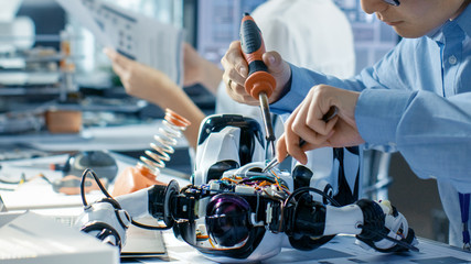 Wall Mural - Electronics Engineer Works with Robot, Soldering Wires and Circuits. Computer Science Research Laboratory with Specialists Working.