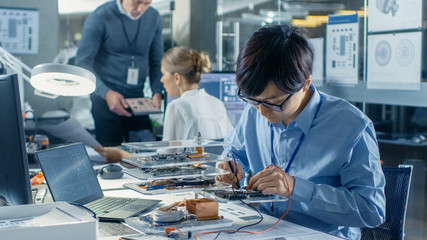 Wall Mural - Electronics Engineer Works with Robot, Soldering Wires and Circuits. Computer Science Research Laboratory with Specialists Working.