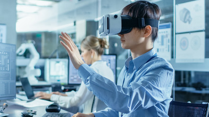 Wall Mural - computer science engineer wearing virtual reality headset works with 3d modeling, makes gestures. in