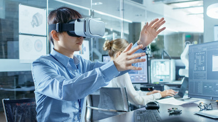 Wall Mural - computer science engineer wearing virtual reality headset works with 3d modeling, makes gestures. in
