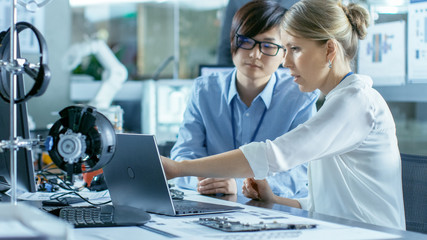 Wall Mural - asian scientist sitting at his desk consults engineer about sophisticated coding and programming. in