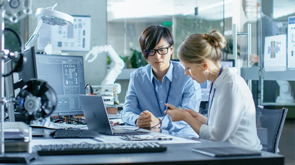 Wall Mural - asian scientist sitting at his desk consults engineer about sophisticated coding and programming. in