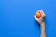 woman holding a stress ball in her hand on blue background