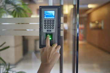 Yong man or woman thumb down finger down on the electronic control machine to access the door 