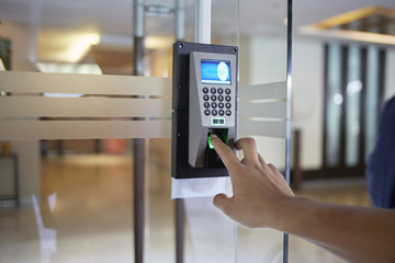 Yong man push finger down the electronic control machine to access the door