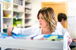 © luismolinero - Woman customer in the pharmacy taking a medicine box