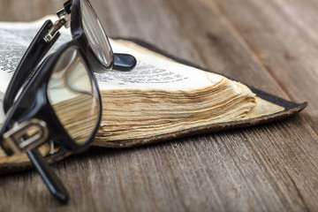 Ancient holy book of a wooden cross on a cord.