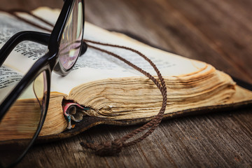 Ancient holy book of a wooden cross on a cord.