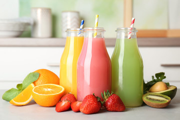 Poster - Bottles with tasty juices and ingredients on table