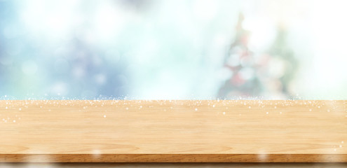 Fototapete - Empty wood board table top with abstract bokeh blur christmas tree and snow fall background with bokeh light,Holiday backdrop,Mock up banner for display or montage of product