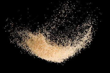 Brown sugar flying explosion splash isolated on black background  ,throwing freeze stop motion element food and drink object design