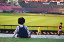 試合終了後の野球場で佇む男の子