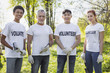 © zinkevych - Environment sector. Energetic four volunteers standing and holding garden tools