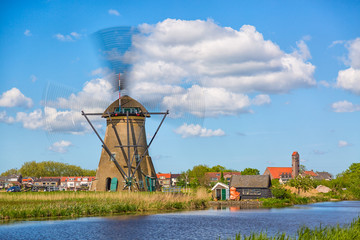 Wall Mural - Famous windmills in Kinderdijk village in Holland. Spinning windwill. Colorful spring landscape in Netherlands, Europe. UNESCO World Heritage and famous tourist site.