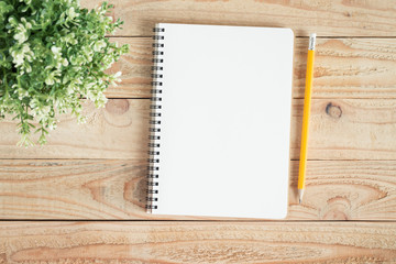 Wall Mural - blank notebook and yellow pencil on brown wood,flat lay photo of notebook for your message