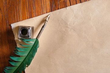 Quill pen and black inkwell on a old paper