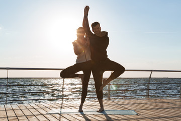 Sticker - Happy young sports couple practicing yoga together