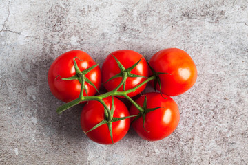 a bunch of red ripe fresh tomato on a stone surface. copy space