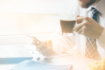 Wall Mural - Young businessman using smartphone during breakfast Light toning