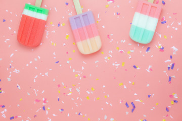 Table top view aerial image of food for summer holiday background concept.Flat lay arrangement variety ice cream pop stick on modern rustic pink paper wallpaper at office desk.Pastel tone design.