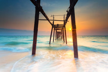 Beautiful Sunset On The Beach With Old Wooden Bridge.