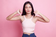 © halfbottle - Unhappy Asian girl show thumbs down with both hands.