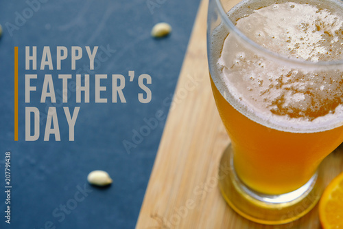 Happy father\'s day graphic with pint of beer and snacking peanuts in background.  Text for holiday card or banner on black background.