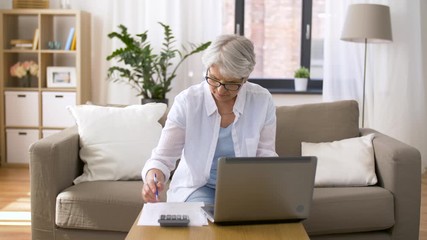 Wall Mural - business, accountancy and people concept - senior woman with papers or bills, laptop computer and calculator at home