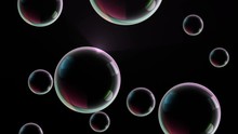 Big Rainbow Soap Bubbles Fly Up Across Black Background. 4K Close Up Seamless Loop Animation. Can Be Added To Party Happy Footage By Doing A Composite Add.