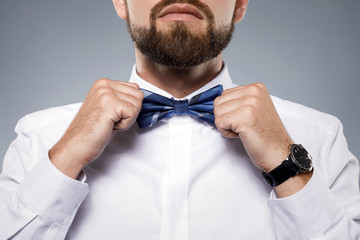 Man is fiting up a beautiful bow tie