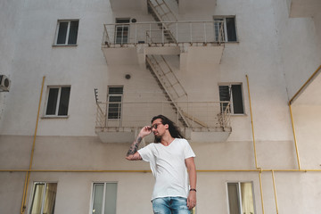 Wall Mural - Stylish man posing on building background