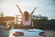 © Yakobchuk Olena - Freedom. Back view of happy positive friends are travelling in fashionable cabriolet with open roof. They are sitting in car with raised hands while enjoying summer vacation. Luxury lifestyle concept