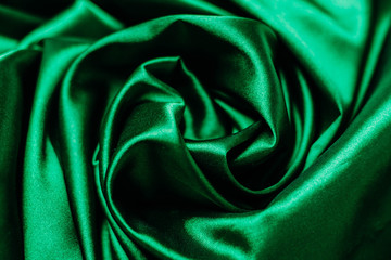 Green fabric in the folds. drapery. shine on silk. Sewing