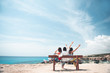 © Yakobchuk Olena - Fun together. Full length back view of three cheerful girls are sitting on bench and looking at azure ocean. They are expressing gladness with raised hands. Summer trip concept and copy space
