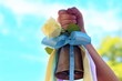 School. The last call or September 1st. Bell in the hands of the child. It is decorated with colored ribbons of pastel tones and a white rose. The concept of the beginning or end of the school year.